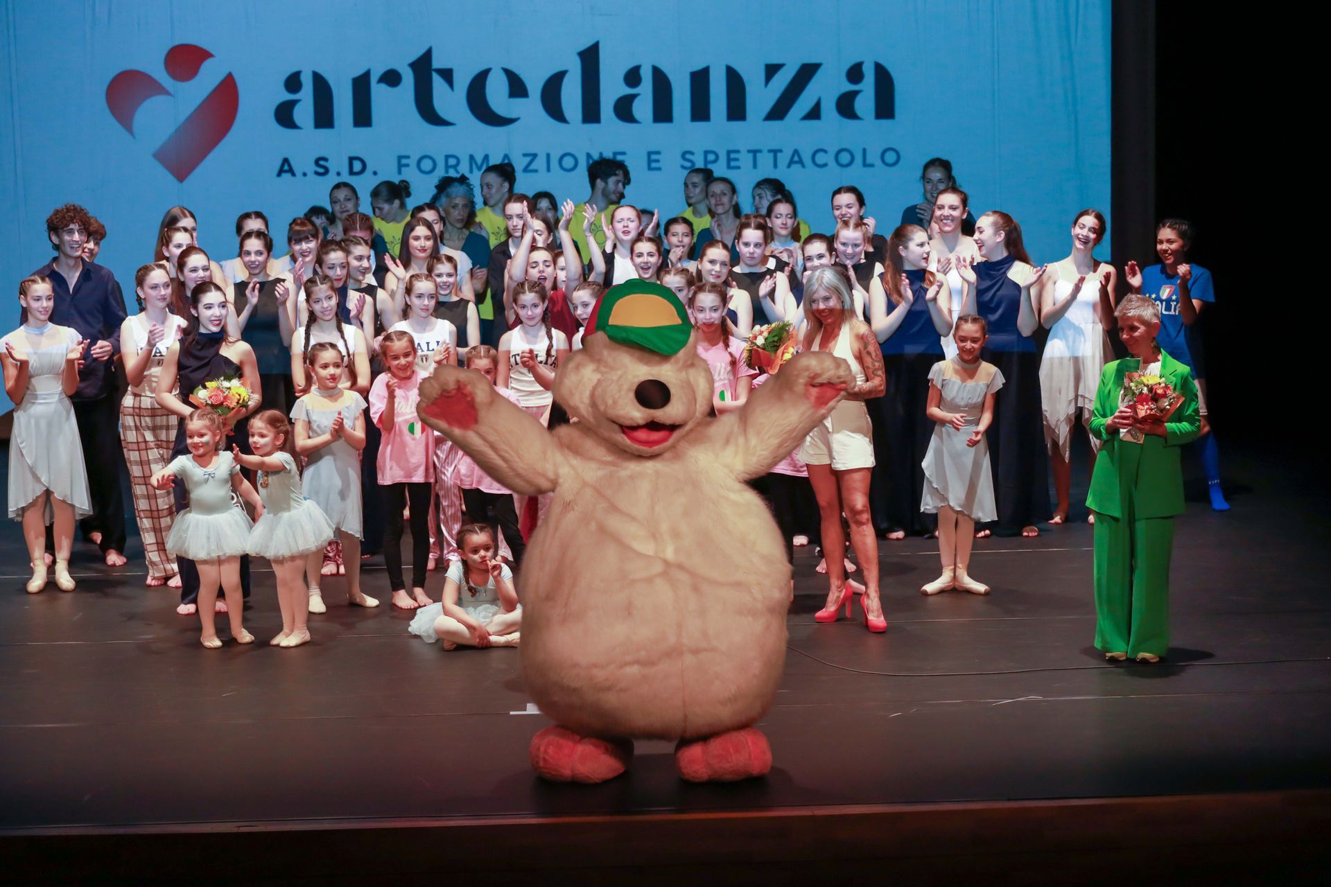 Un gruppo di persone in piedi davanti a un cartello che dice artedanza