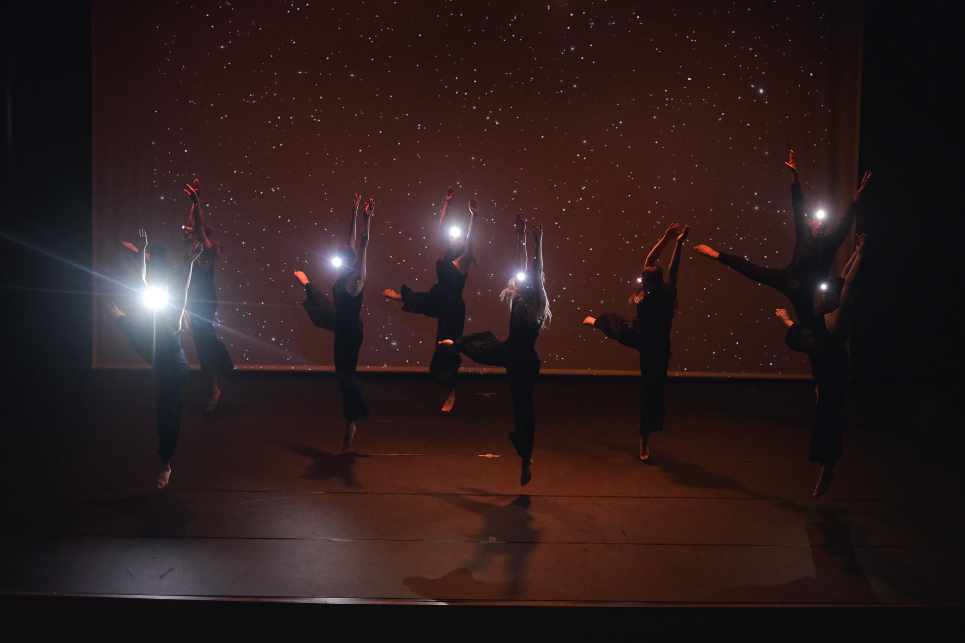 Un uomo salta in aria mentre balla su un palco.