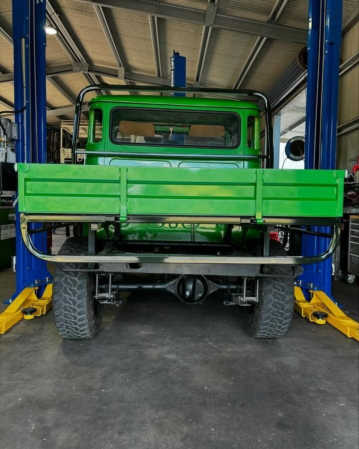 Green Truck on a Lift in a Garage — Atherton Mechanical Services in Atherton, QLD