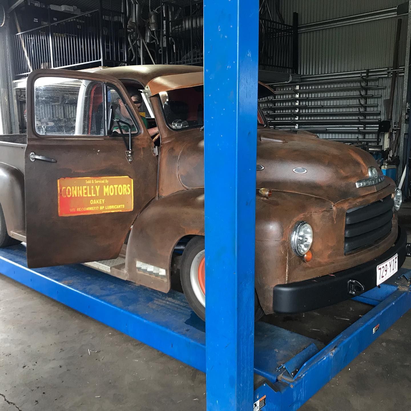 Rusty Vintage Pickup Truck on a Blue Lift — Atherton Mechanical Services in Atherton, QLD