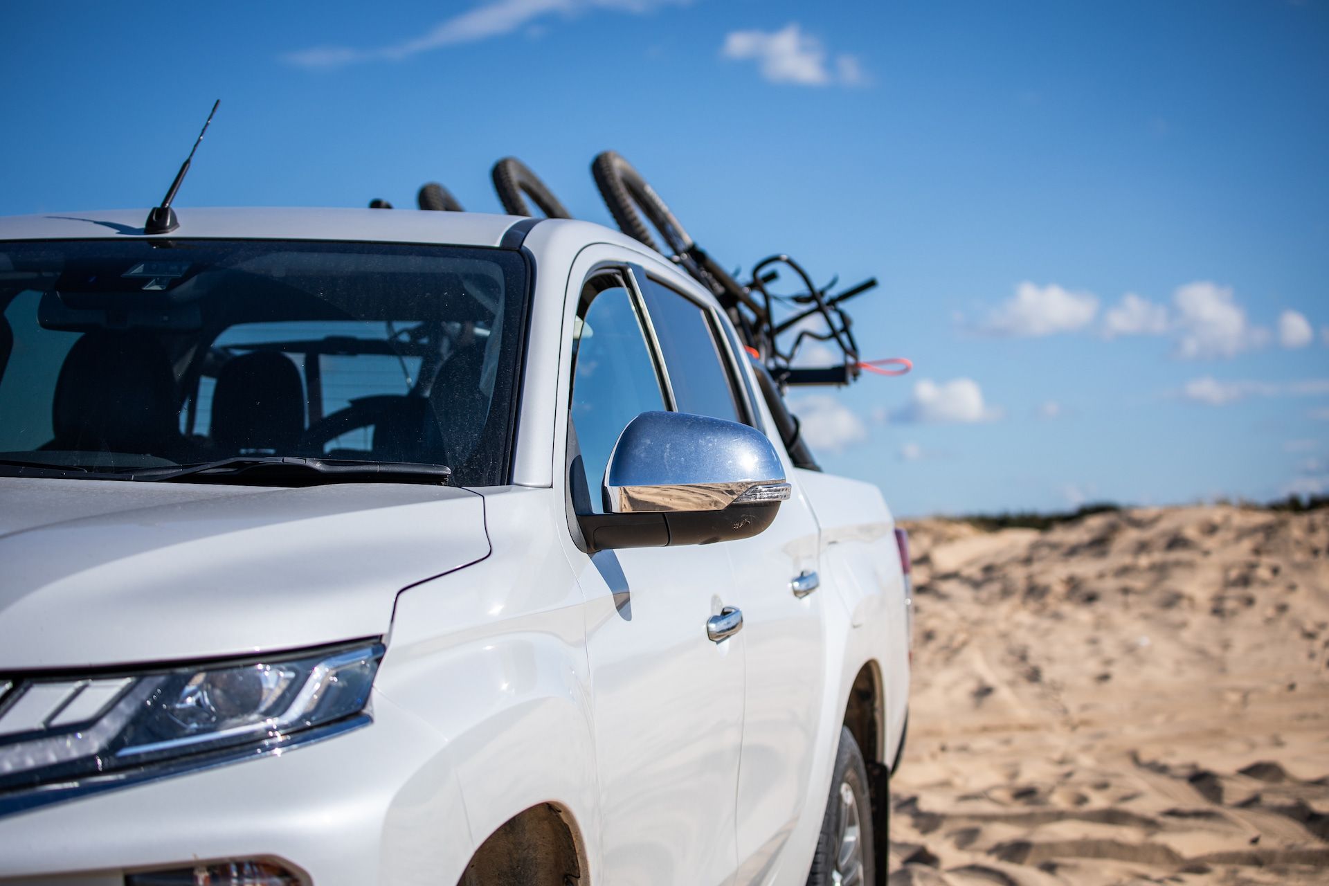 White Pickup Truck Parked on Sand With Bicycles on the Rack — Atherton Mechanical Services in Atherton, QLD