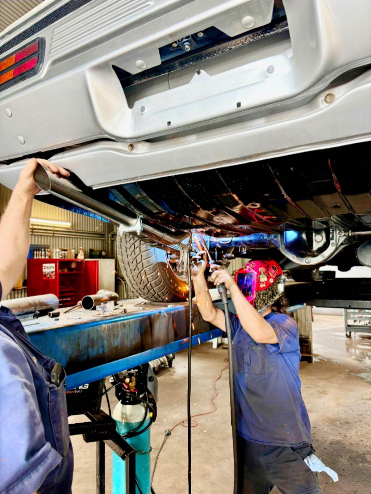 A Mechanic Welding Under a Vehicle — Atherton Mechanical Services in Atherton, QLD