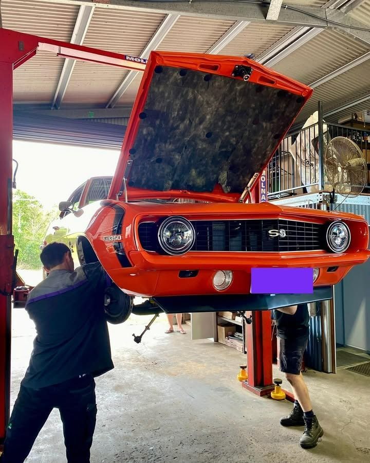 Two Mechanics Working on an Orange Classic Car — Atherton Mechanical Services in Atherton, QLD