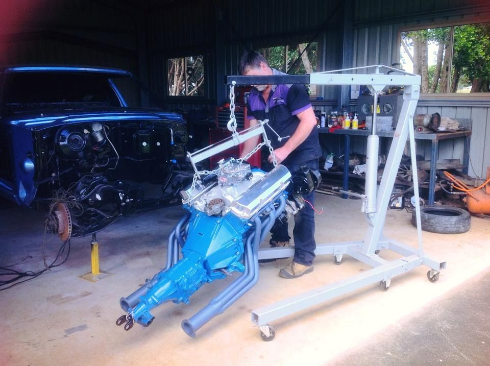 Mechanic Using a Hoist to Lift a Blue Engine From a Car — Atherton Mechanical Services in Atherton, QLD