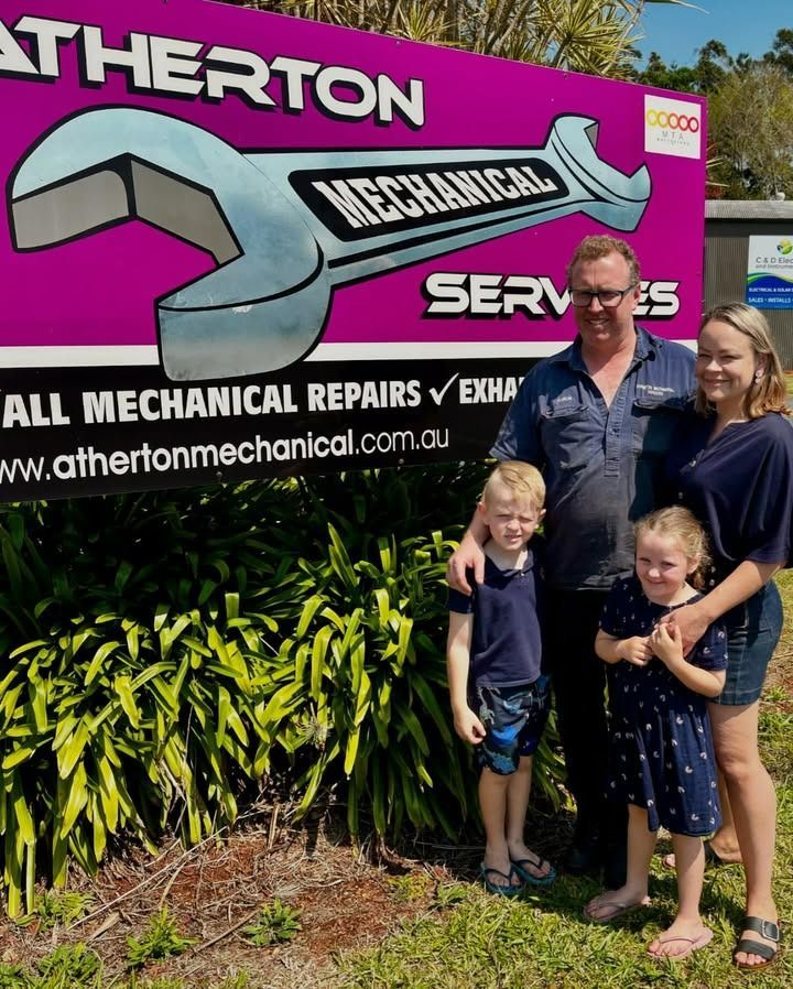 Family Standing by a Sign for Atherton Mechanical Services — Atherton Mechanical Services in Atherton, QLD
