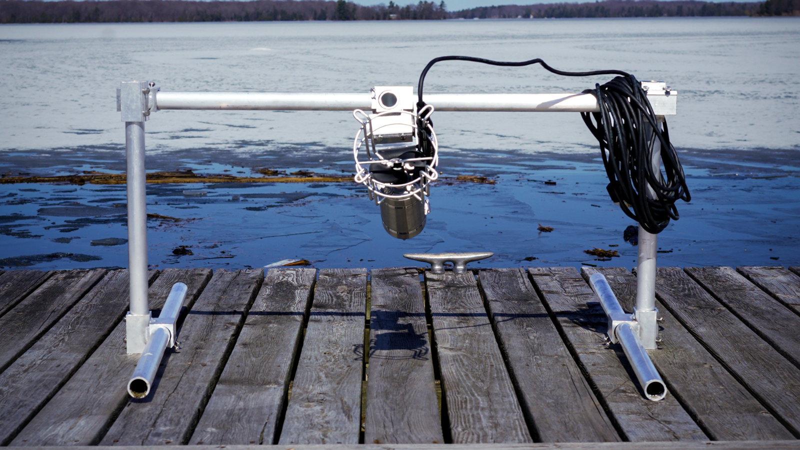 Metal rotisserie device, mounted on supports, with a stainless steel motor and basket, isolated on white.