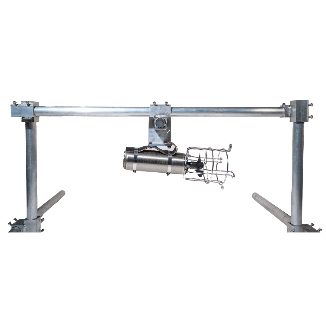 A de-icer hanging over water on a wooden dock. The background is icy water and land.