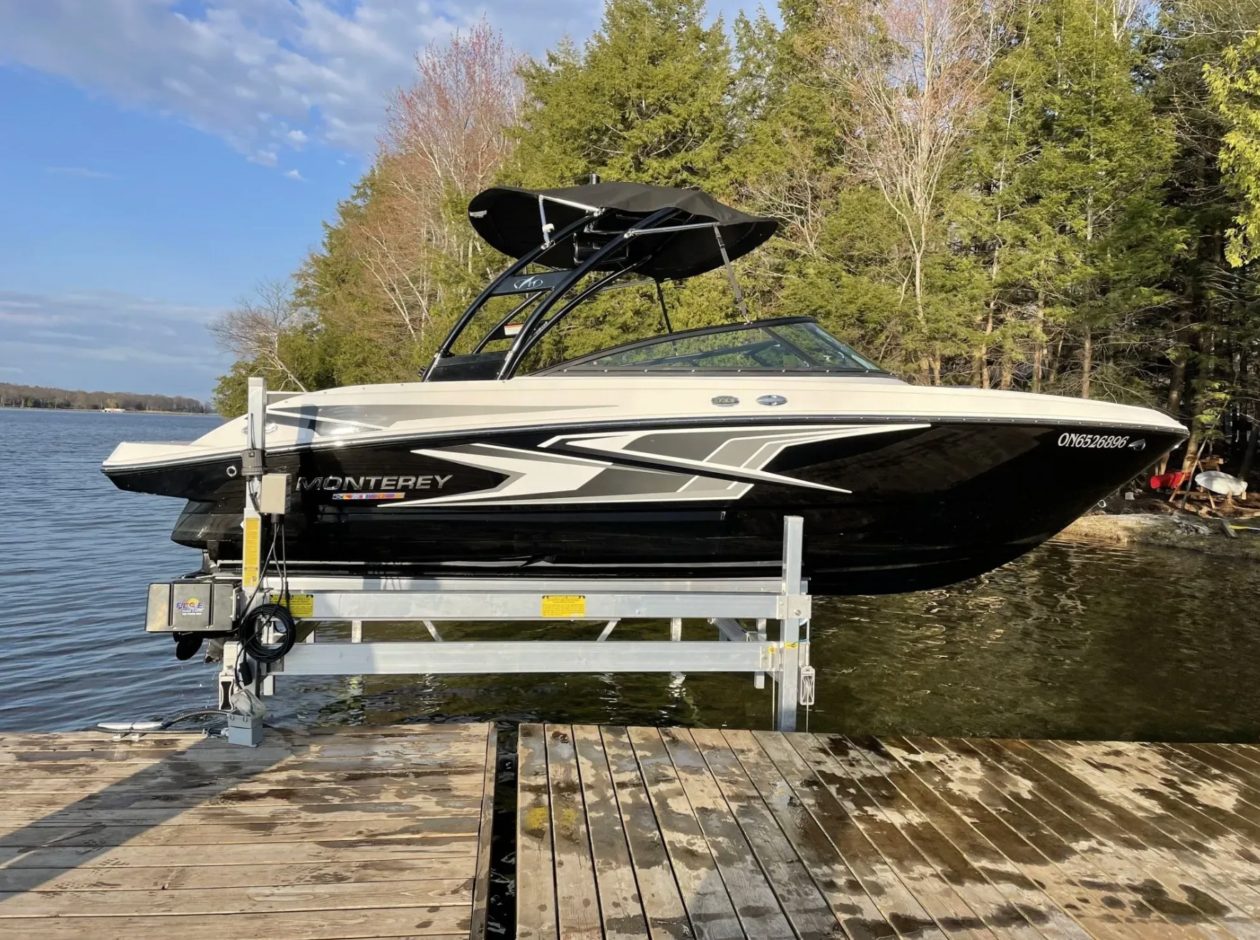 Boat lifted on a dock-mounted boat lift over calm lake water during early spring after ice-out.
