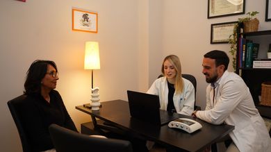 Un gruppo di persone è seduto a un tavolo con un computer portatile.