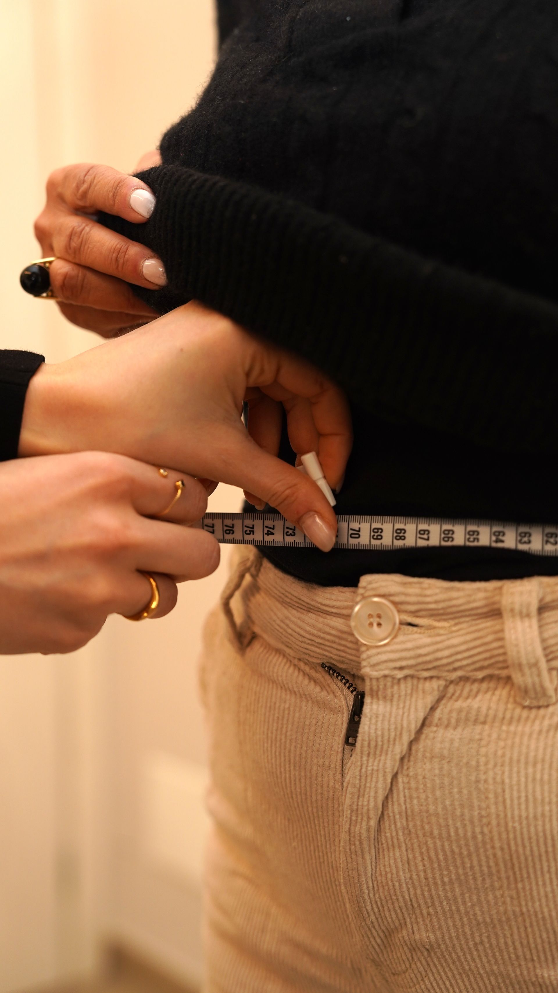Una donna sta misurando la vita di un'altra donna con un metro a nastro.