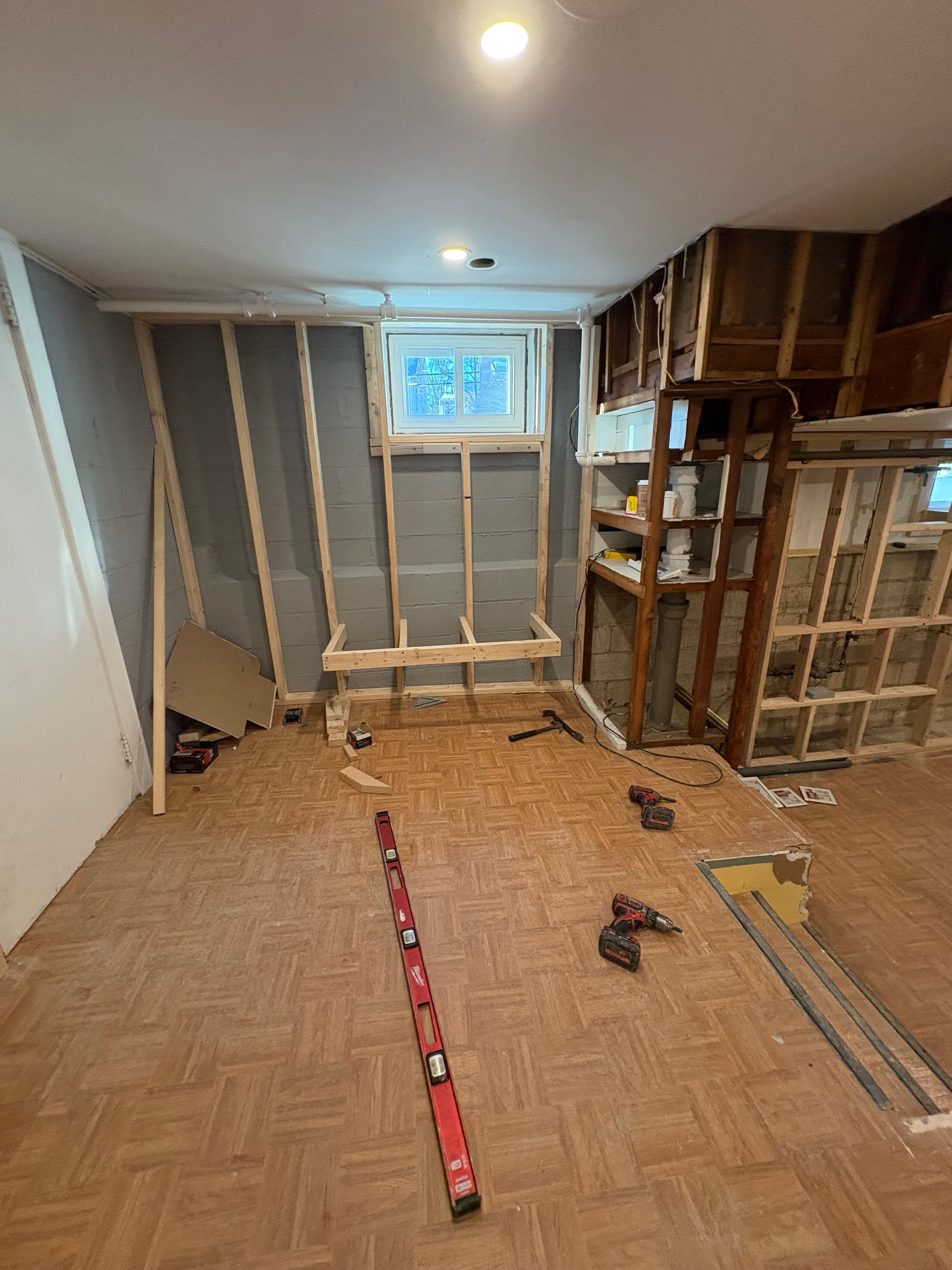 A modern kitchen with white cabinets, granite countertops, stainless steel appliances, and dark wood flooring.