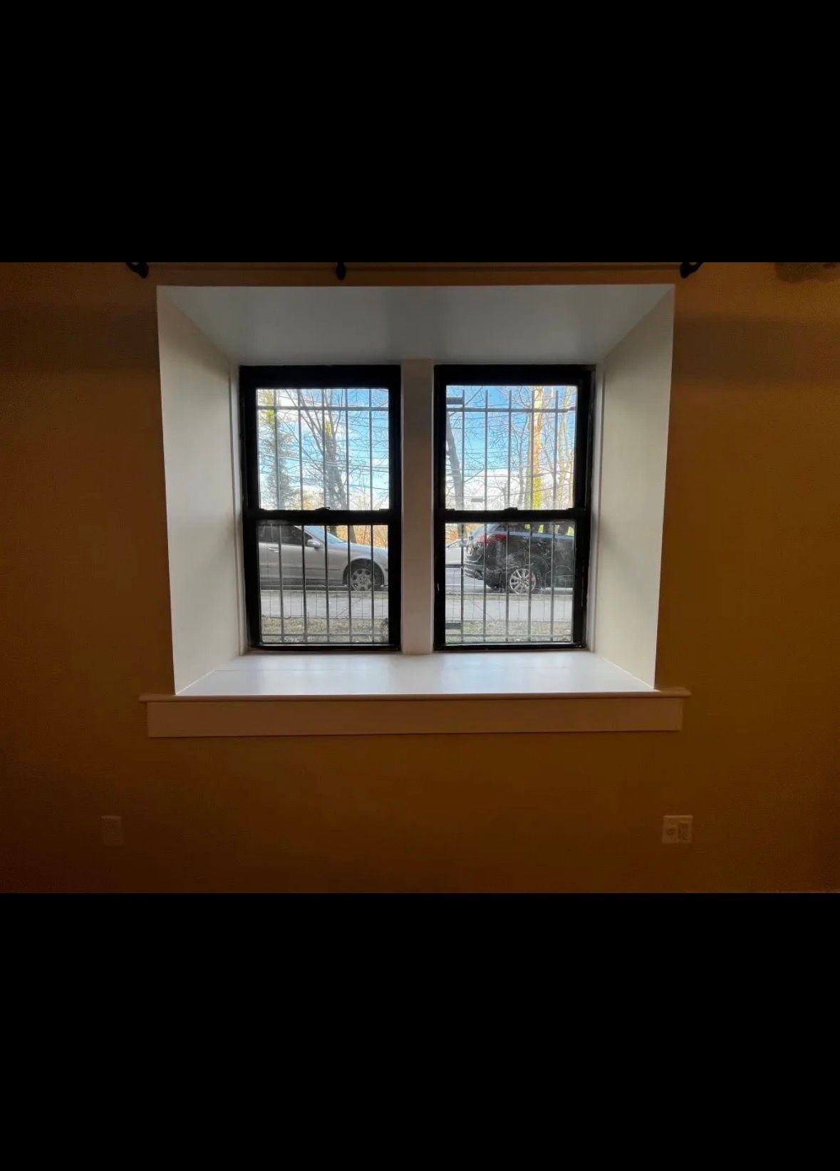 A white stepladder stands in a room undergoing construction, surrounded by tools and materials on a dusty floor.
