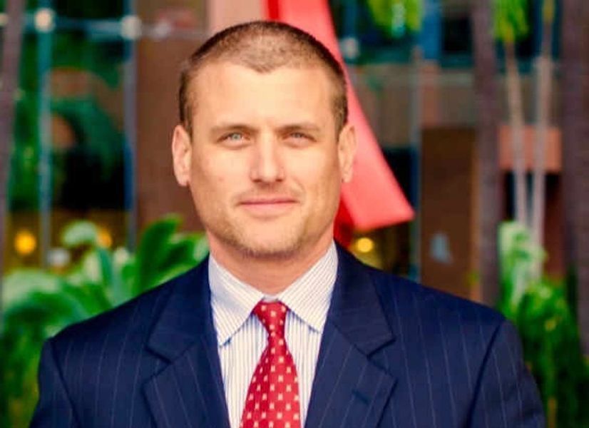 A man in a suit and tie is smiling for the camera.
