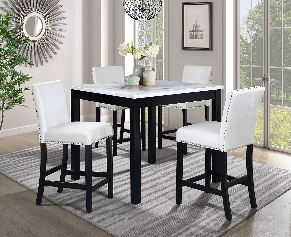 Square black and white dining table with four white chairs on a rug; a sunburst mirror on the wall.