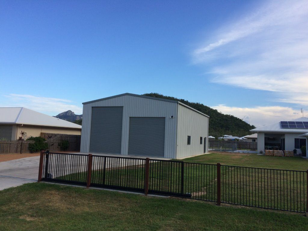 A White Garage With a Fence in Front of It and a House in the Background — Shedquarters In Kirwan, QLD