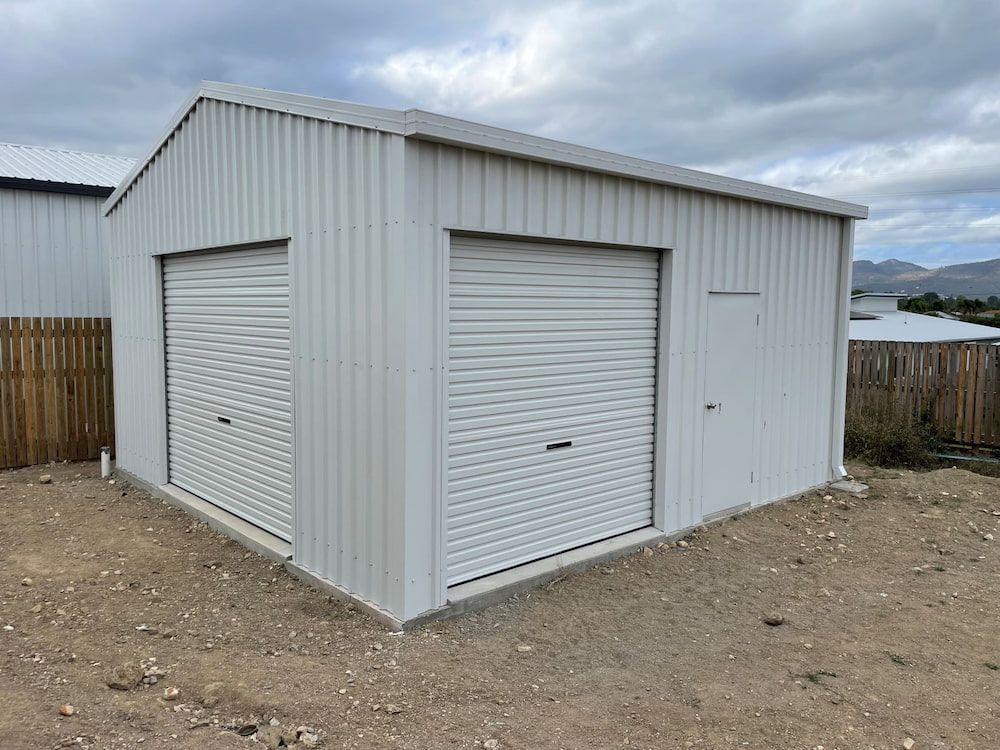 A metal shed is being built in the backyard of a house — Shedquarters In Kirwan, QLD