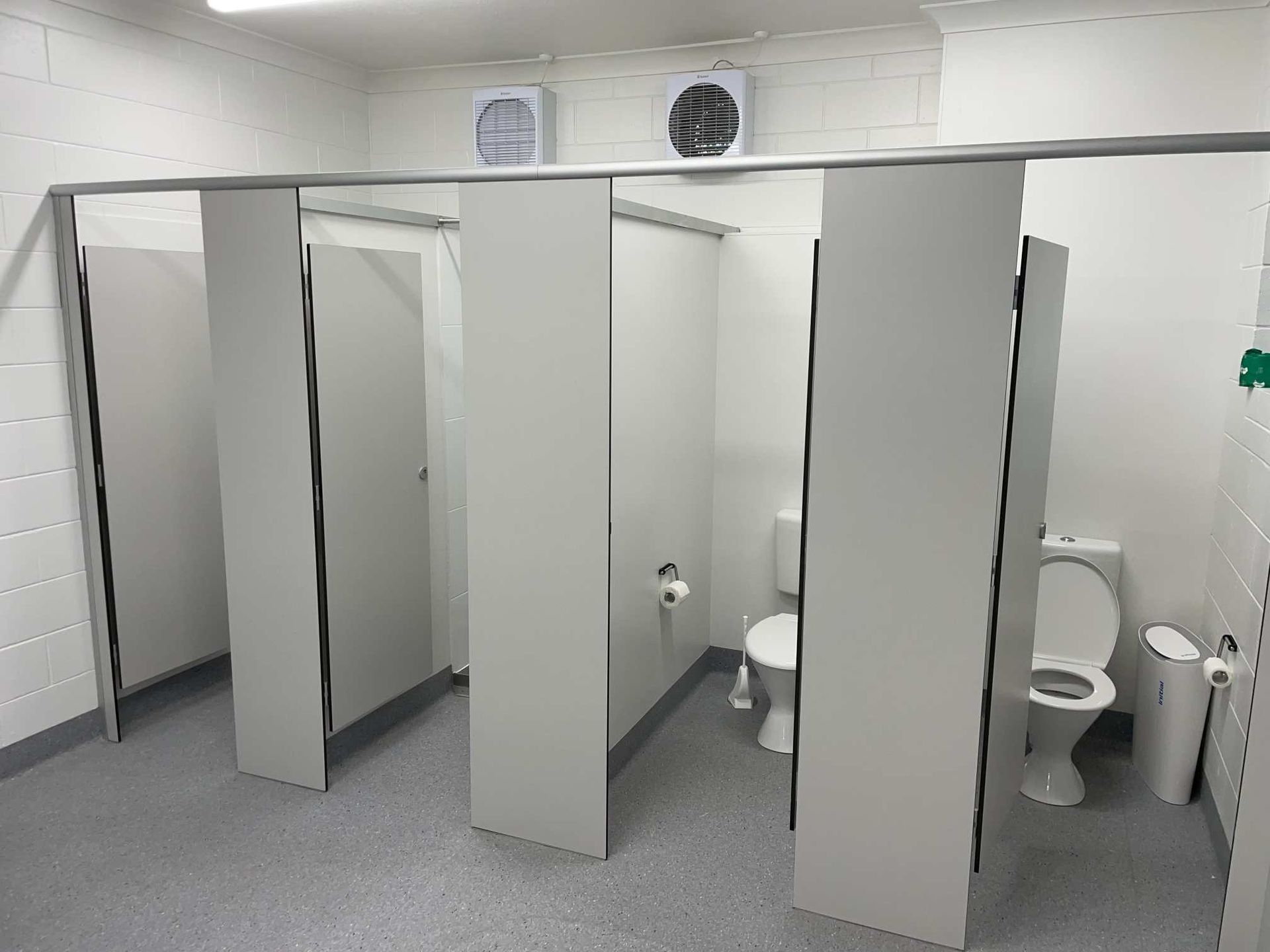 A Bathroom With a Row of Toilets and a Fan on the Ceiling — Shedquarters In Kirwan, QLD
