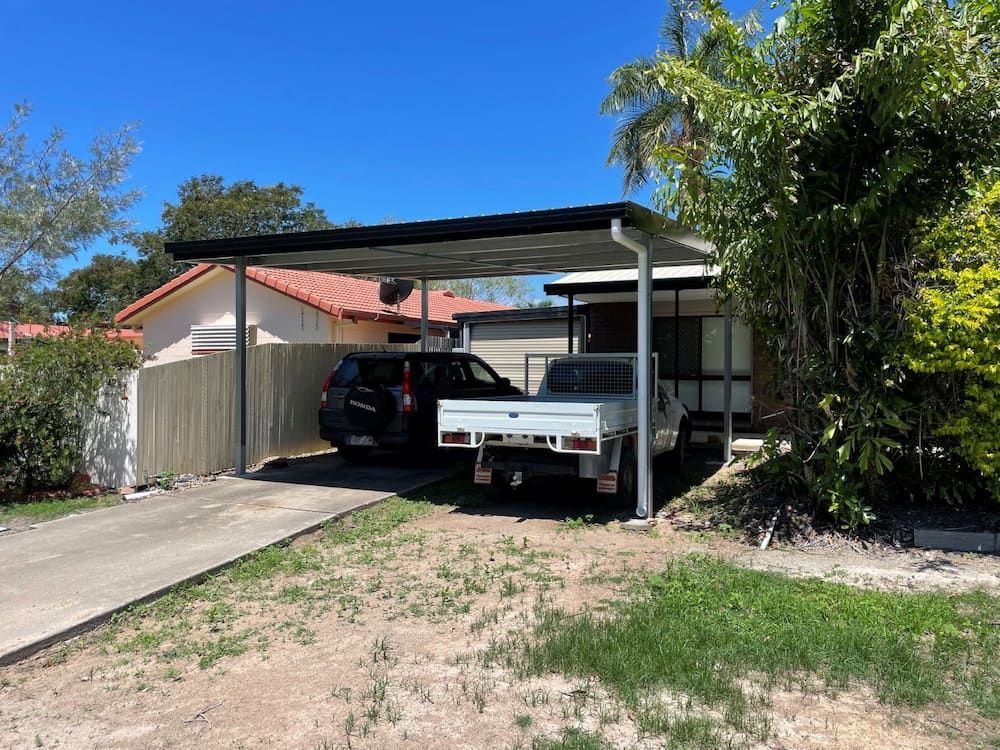 A White Truck is Parked Under a Carport in Front of a House — Shedquarters In Kirwan, QLD