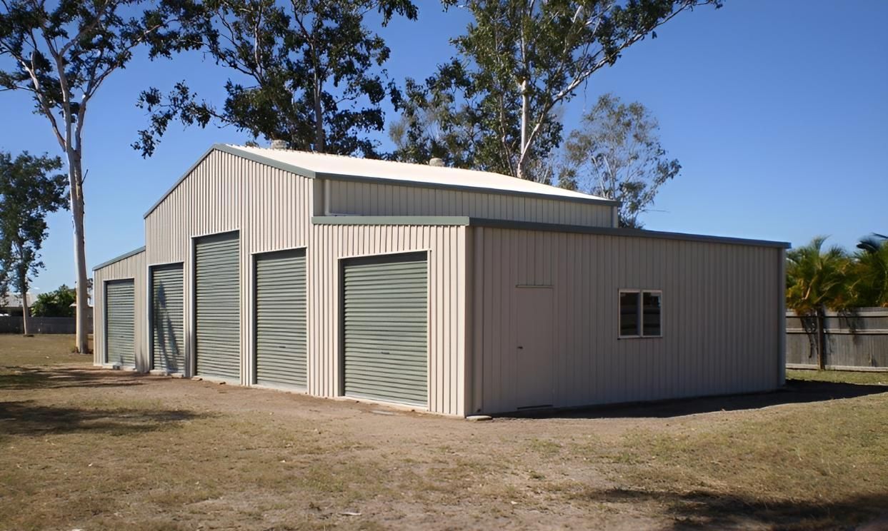 A Building With A White Roof And Green Garage Doors — Shedquarters In Kirwan, QLD