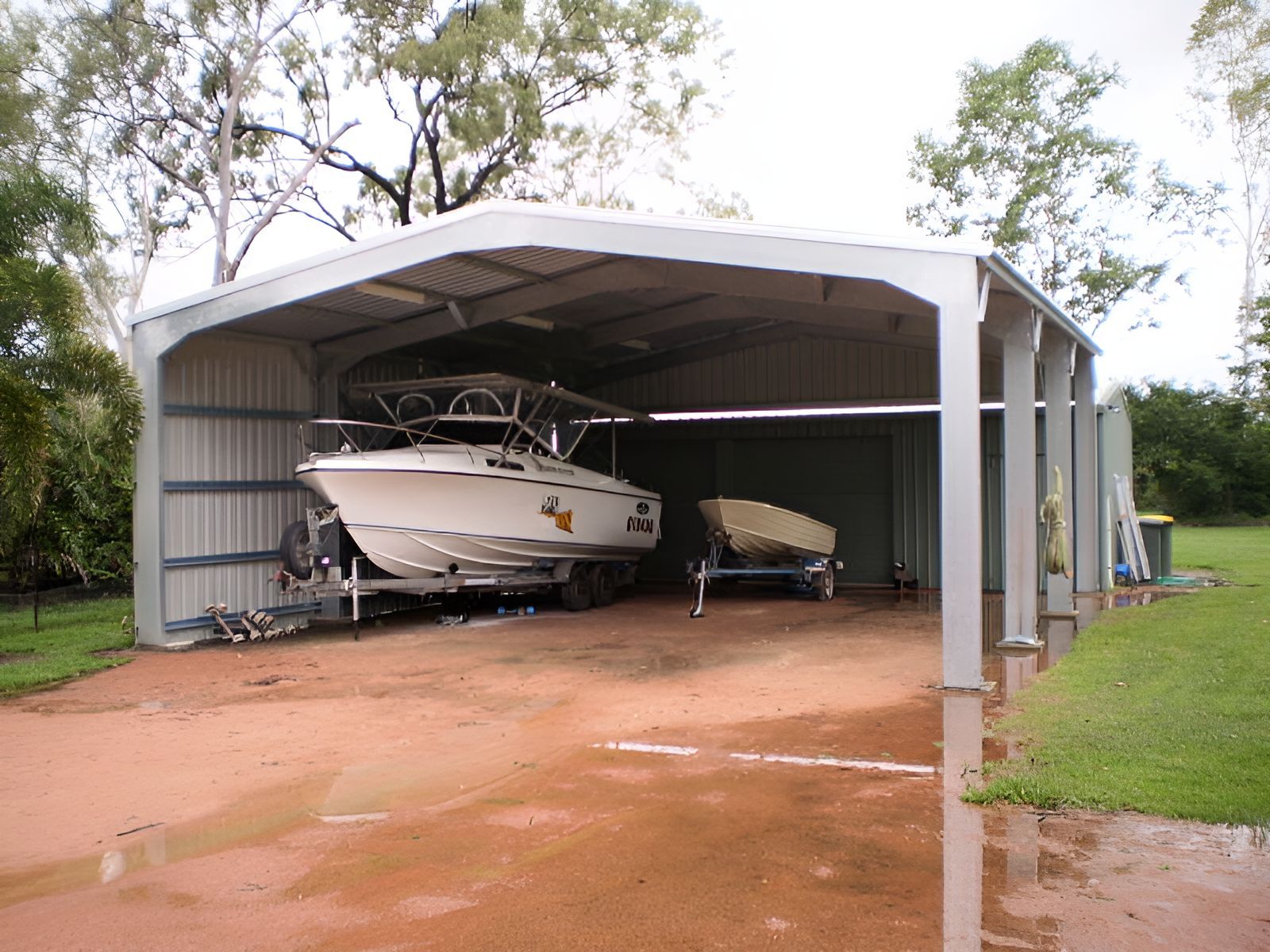 A Boat Is Sitting Under A White Roof In A Garage — Shedquarters In Kirwan, QLD