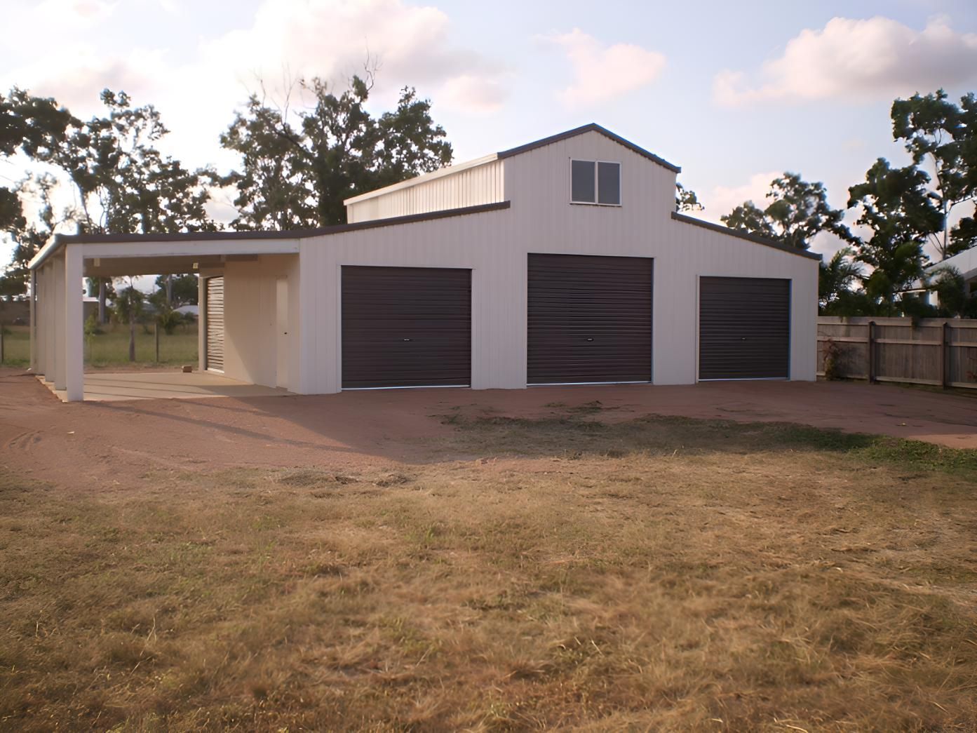A Large White Building With Three Garage Doors — Shedquarters In Kirwan, QLD