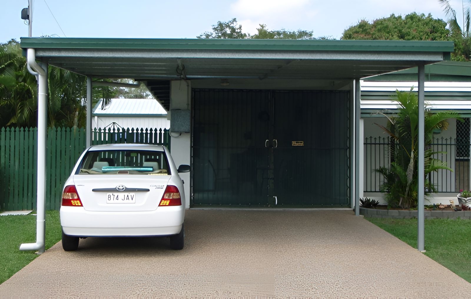 A White Car Is Parked Under A Carport With A Green Roof — Shedquarters In Kirwan, QLD