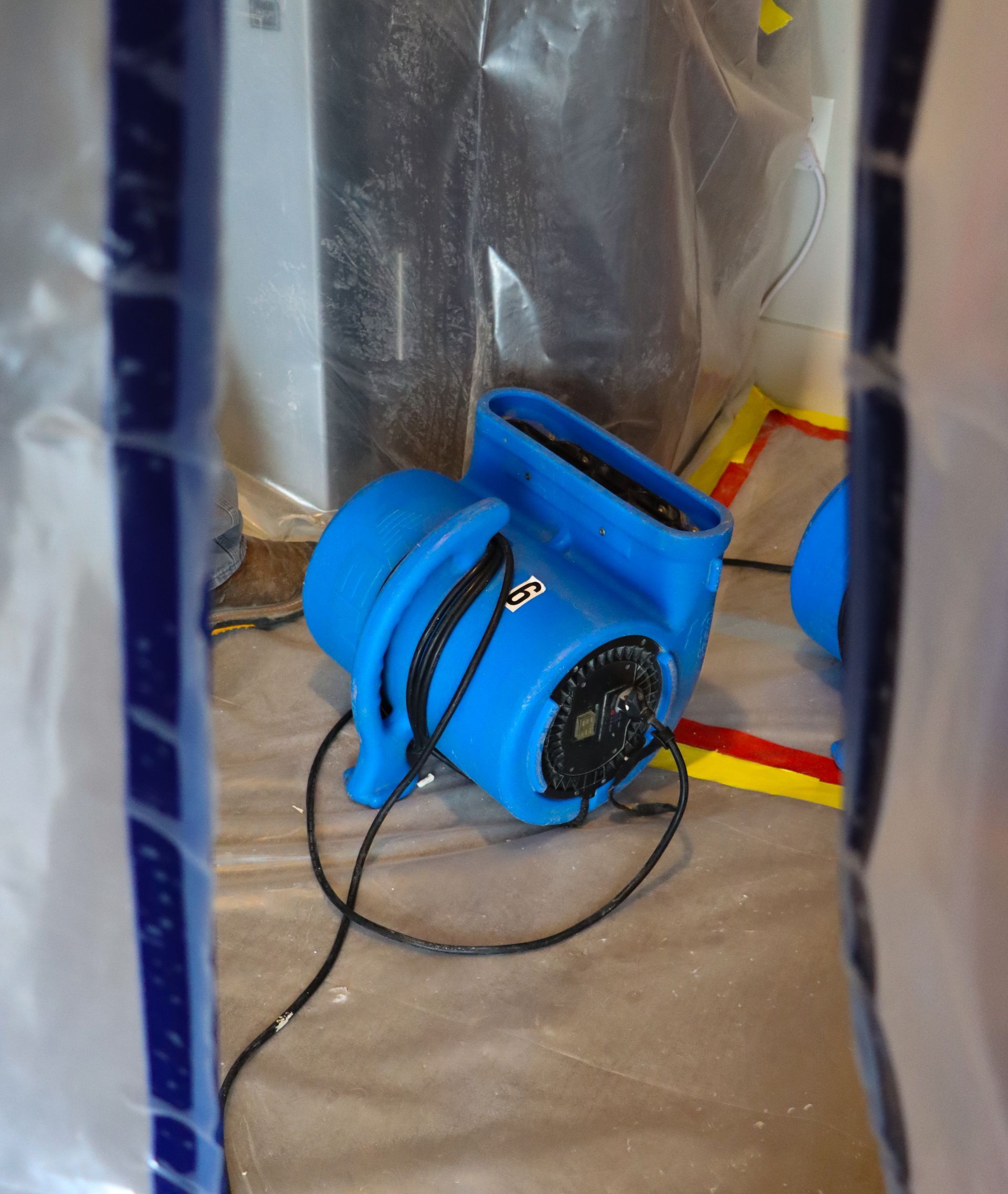 A blue fan is sitting on the floor in a room