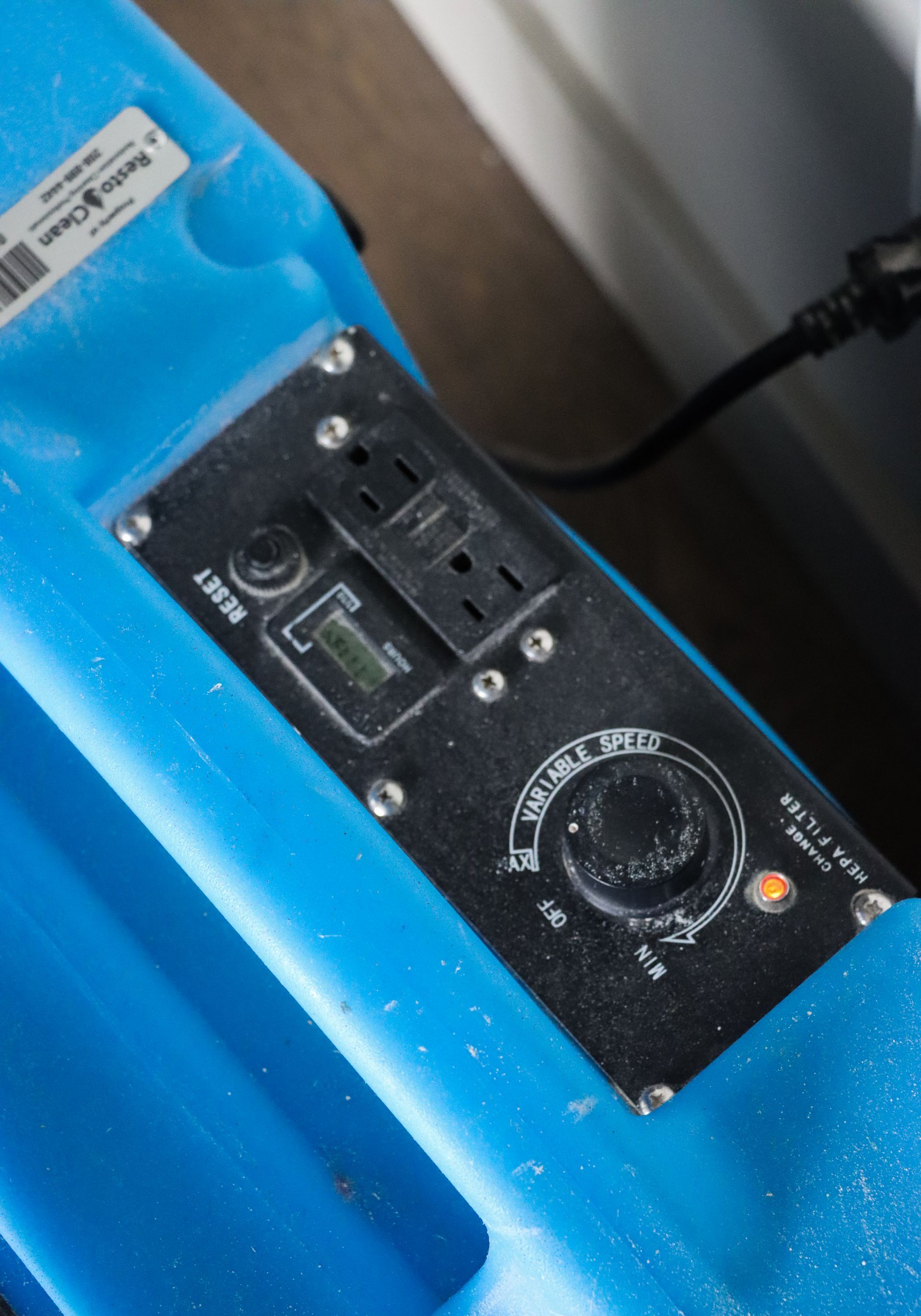 A close up of a blue appliance with a black control panel