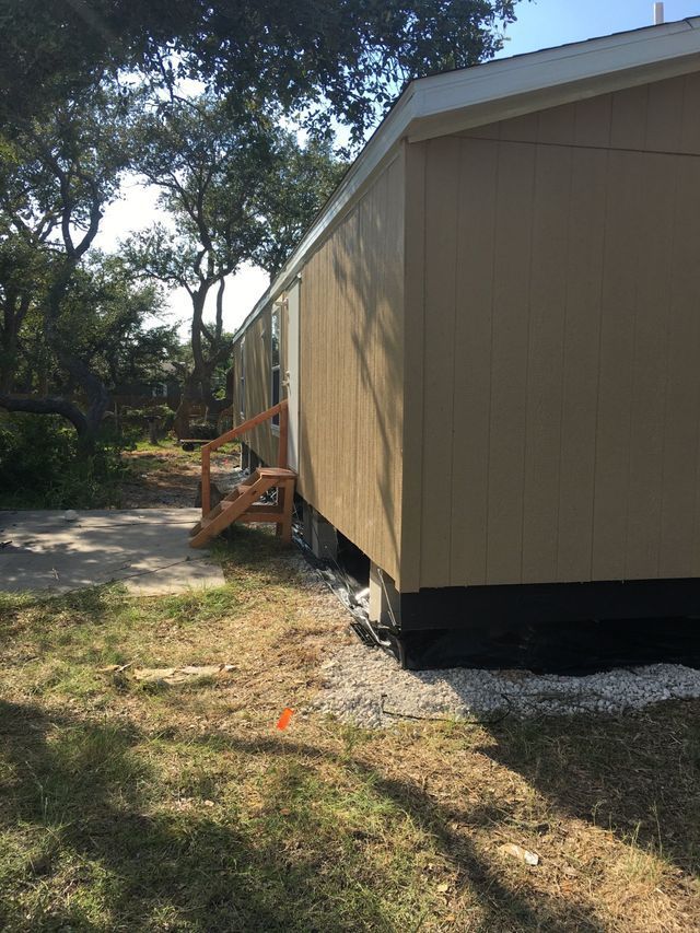 A mobile home with stairs leading up to it in a yard.