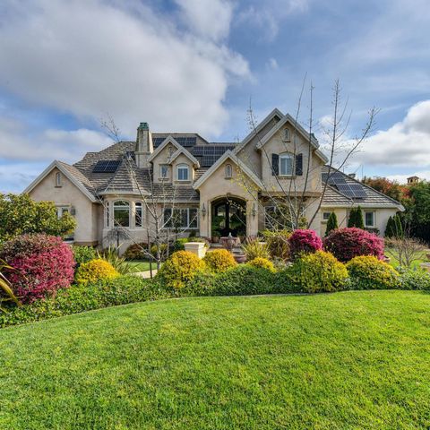 Elegant house with lush green lawn and colorful bushes under a partly cloudy sky. Elegant house with lush green lawn and colorful bushes under a partly cloudy sky.