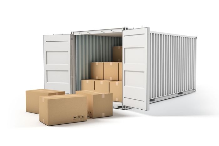 Shipping container, open, loaded with stacked cardboard boxes, with boxes outside.