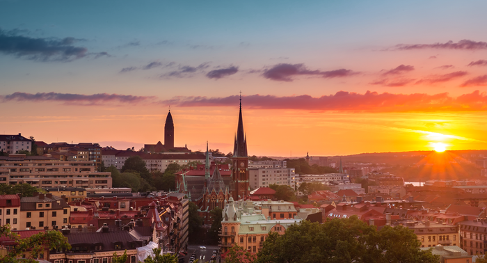 An aerial view of a city at sunset with a sunset in the background.