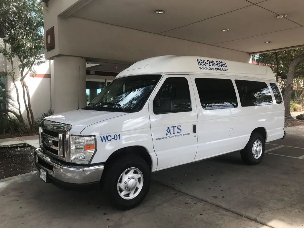 A white van is parked in front of a building.