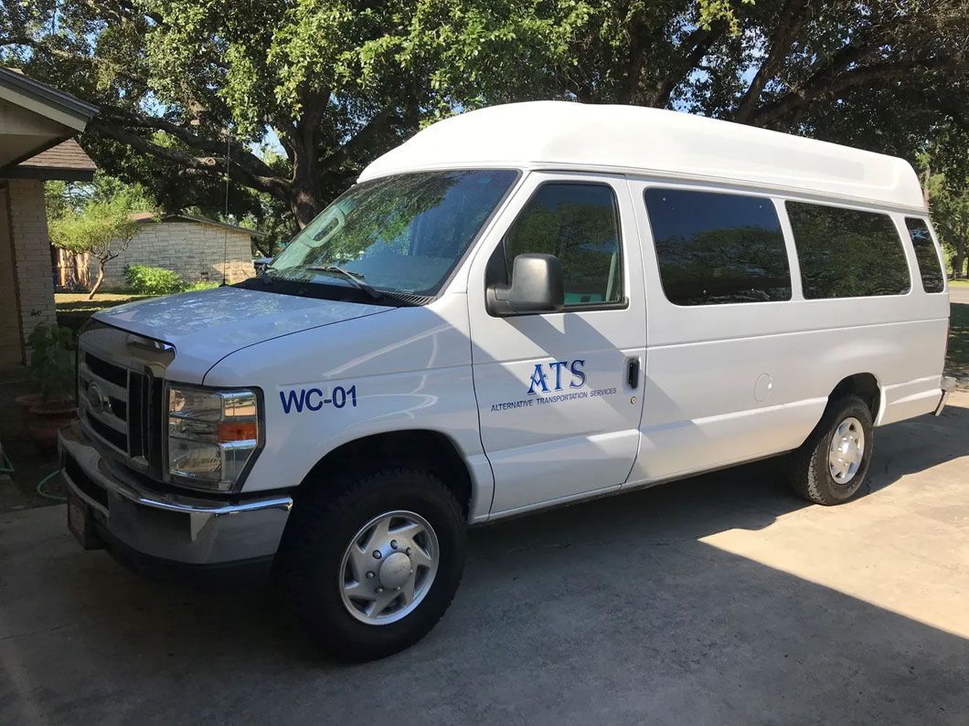 A white van with the word ats on the side is parked in a driveway.