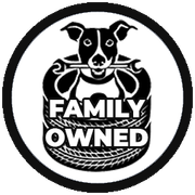 A black and white logo of a dog holding a tire with the words `` family owned '' written on it.