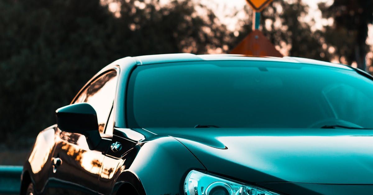 A close up of a blue sports car parked on the side of the road.