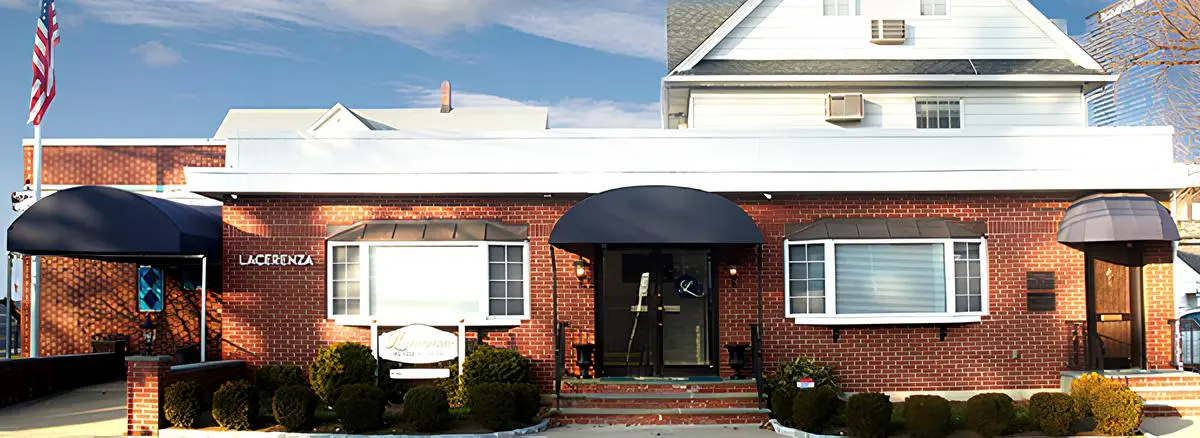 A large brick house with a white roof and black awnings