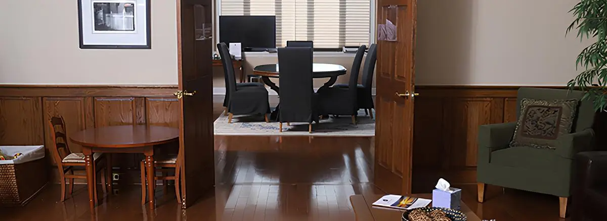 A living room with a table , chairs , and a desk.