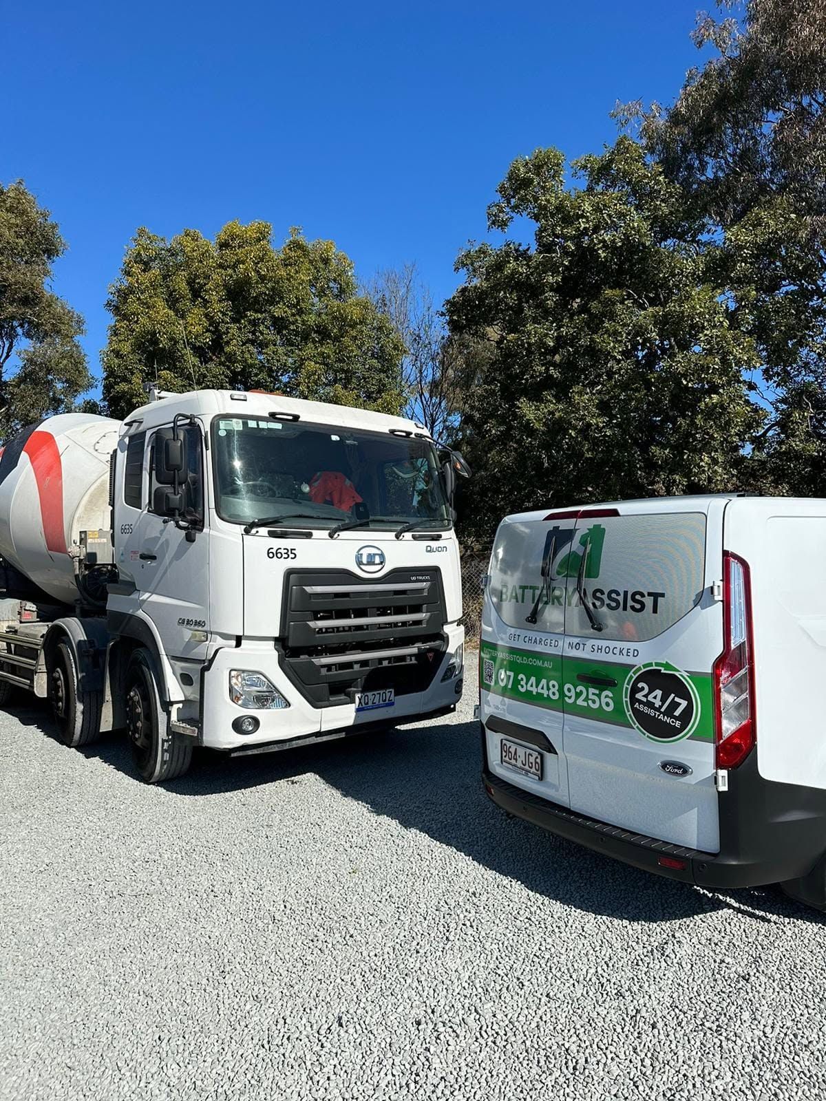 Two White Service Trucks Parked on Gravel Under a Clear Blue Sky — Battery Assist Brisbane in Bribie Island, QLD