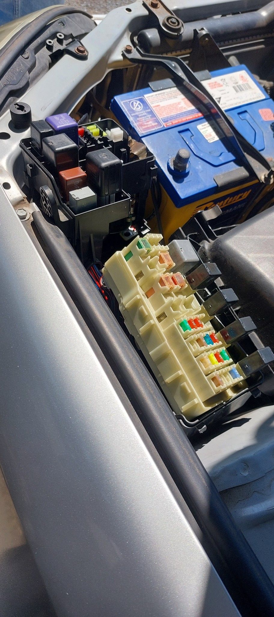 Open Car Engine Bay With Fuse Boxes and a Blue Battery — Battery Assist Brisbane in Redcliffe, QLD