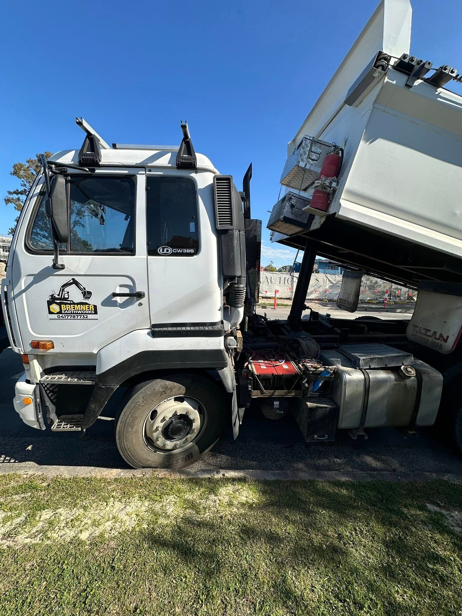 White Dump Truck With Raised Bed, Parked Outdoors on Grass — Battery Assist Brisbane in Caboolture, QLD