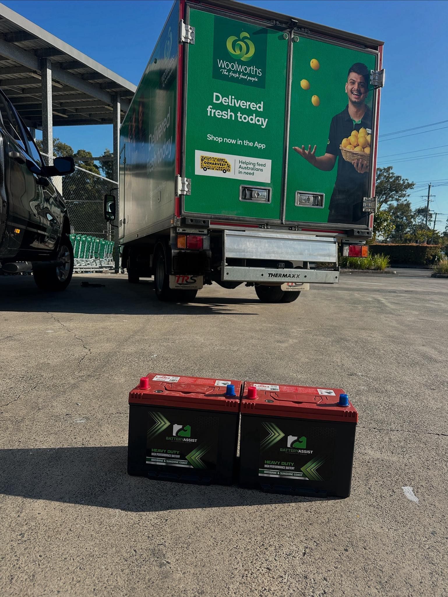 Two Car Batteries in Front of a Green Delivery Truck — Battery Assist Brisbane in Caboolture, QLD