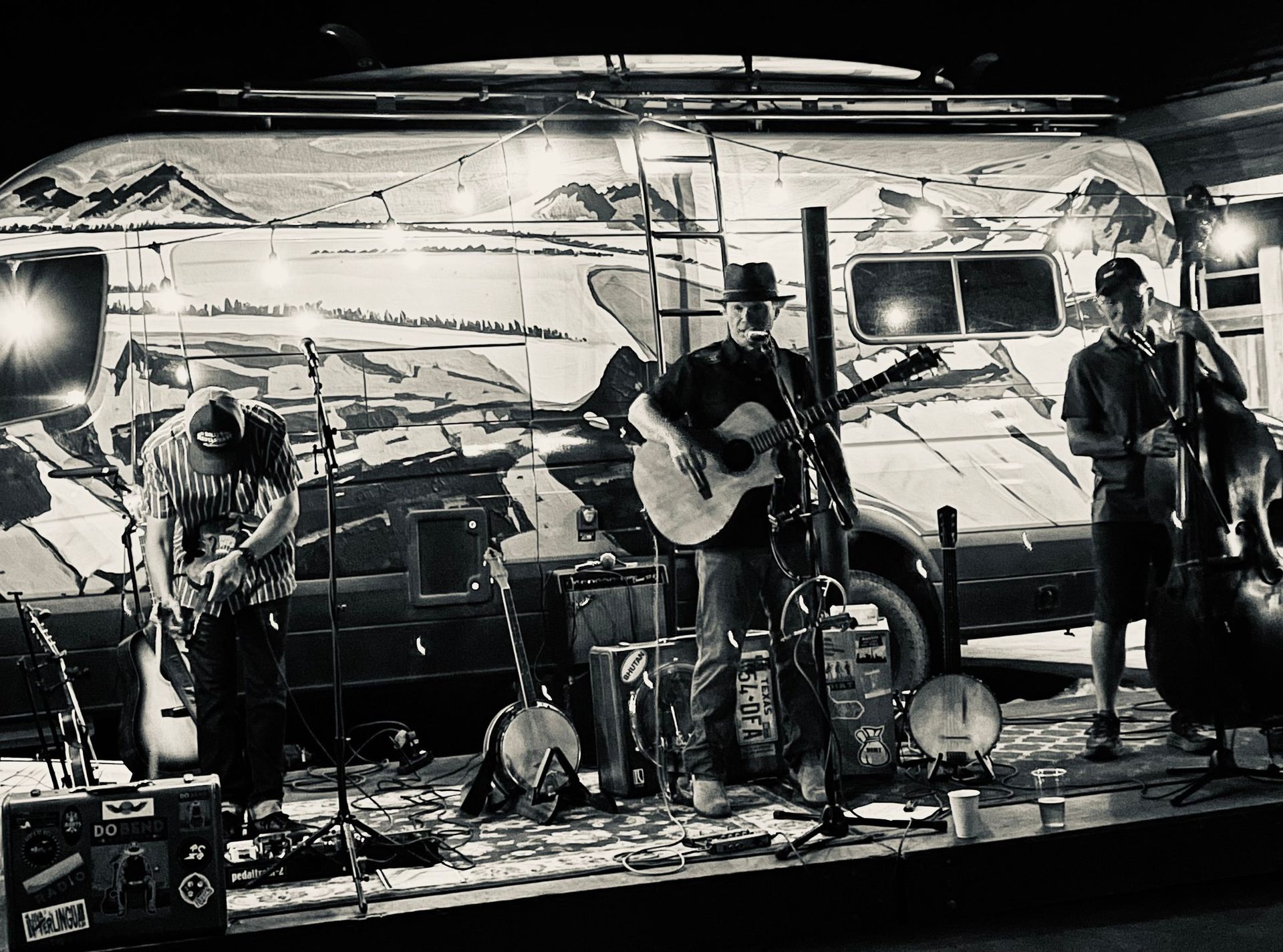 A black and white photo of a group of people playing instruments on a stage.