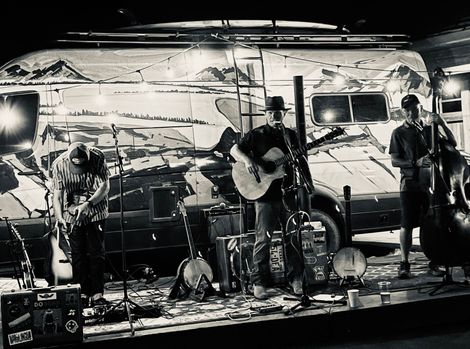A black and white photo of a group of people playing instruments on a stage.