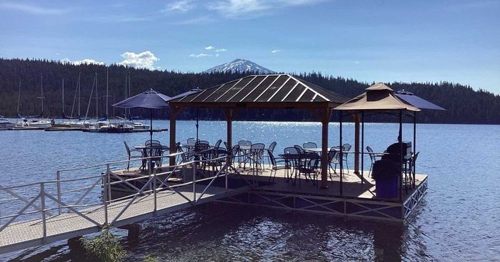 A gazebo is sitting on a dock overlooking a lake.