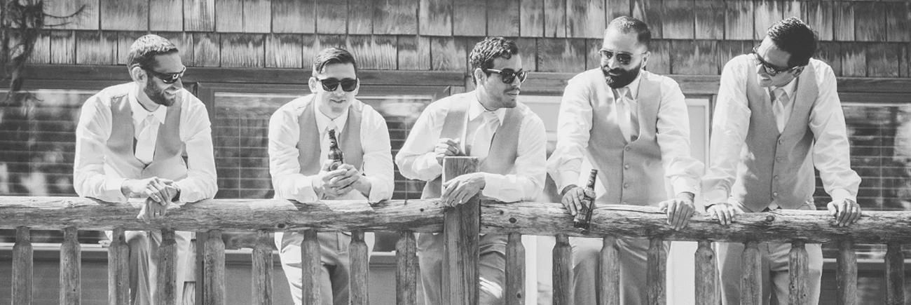 A group of men are standing next to each other on a railing.