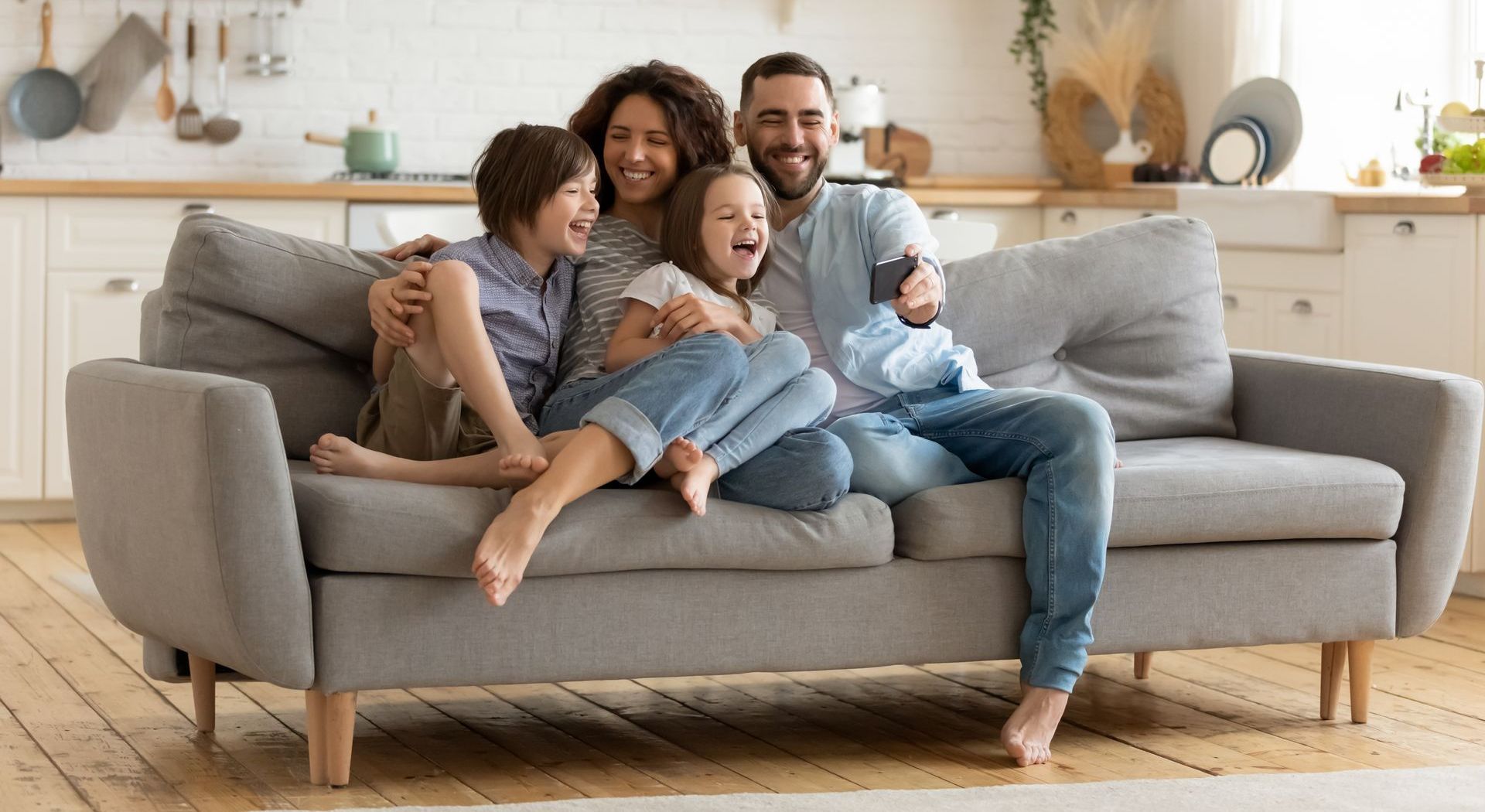 A family is sitting on a couch in a living room.