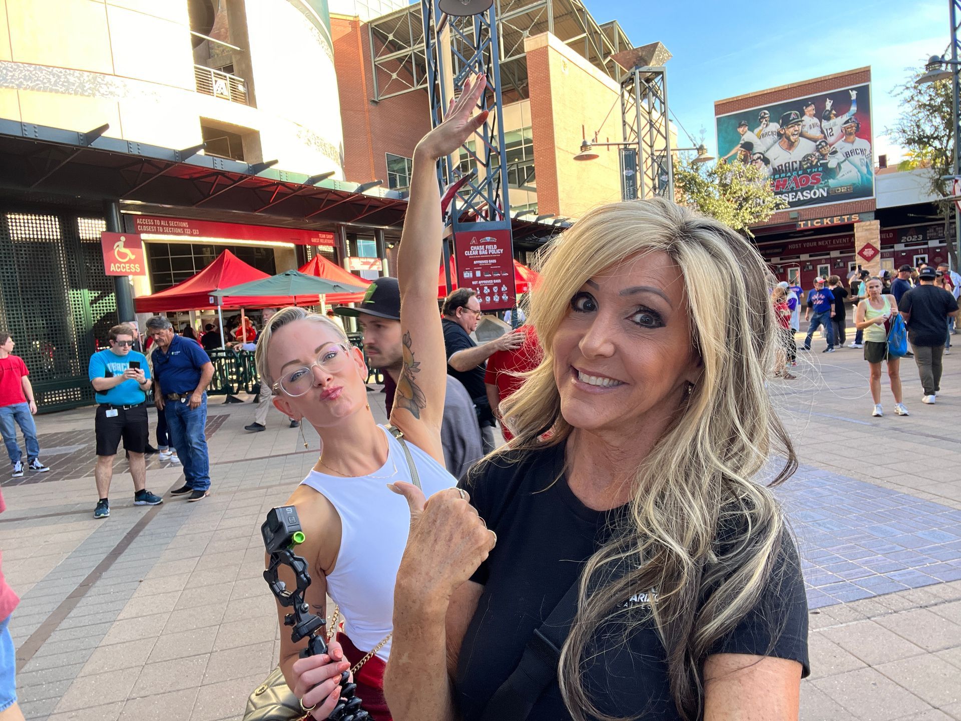 Two women are standing next to each other on a sidewalk.