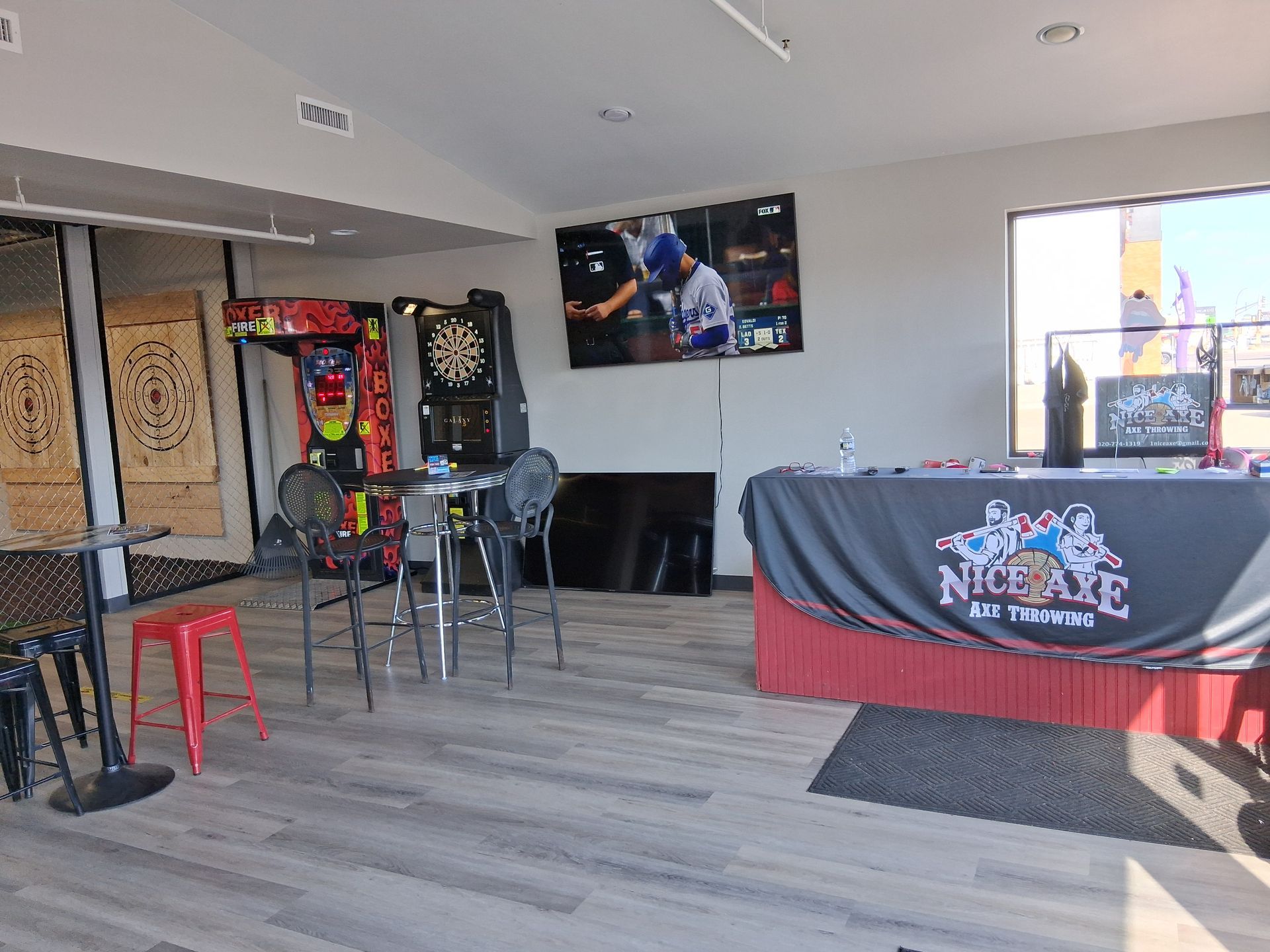 A room with a table , chairs and a dart board.
