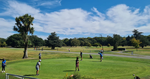 A group of people are playing golf on a golf course.